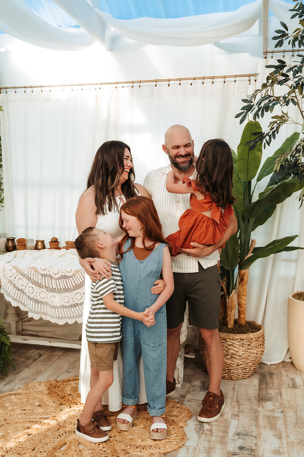 Family smiling at each other during a candid outdoor photo session with Charlotte family photographer